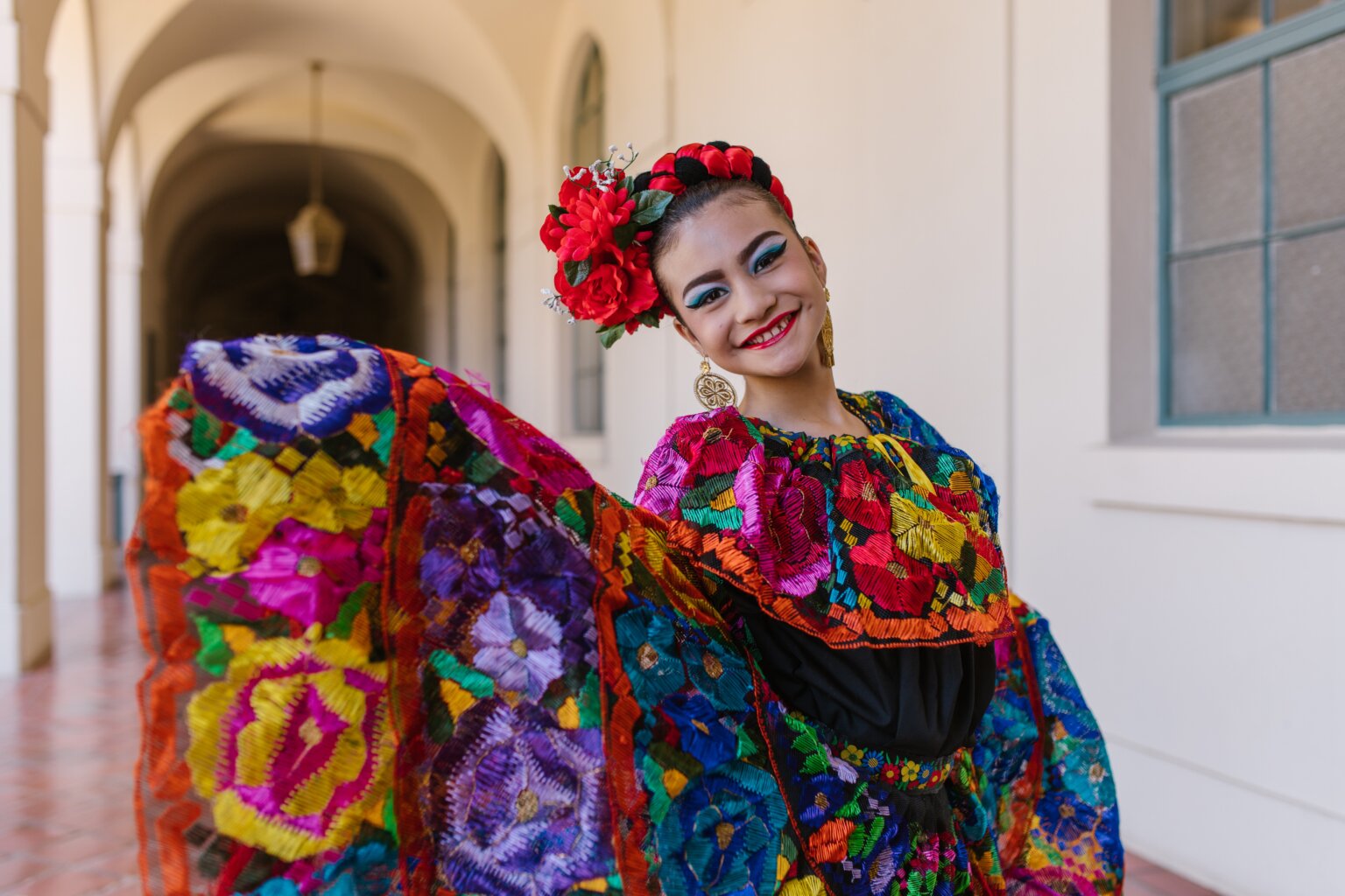 A girl wearing a colorful traditional Mexican dress.