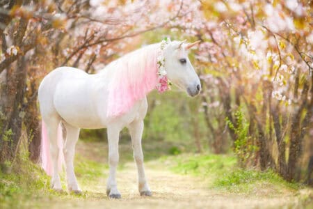 unicorn with pink mane walking through a forest