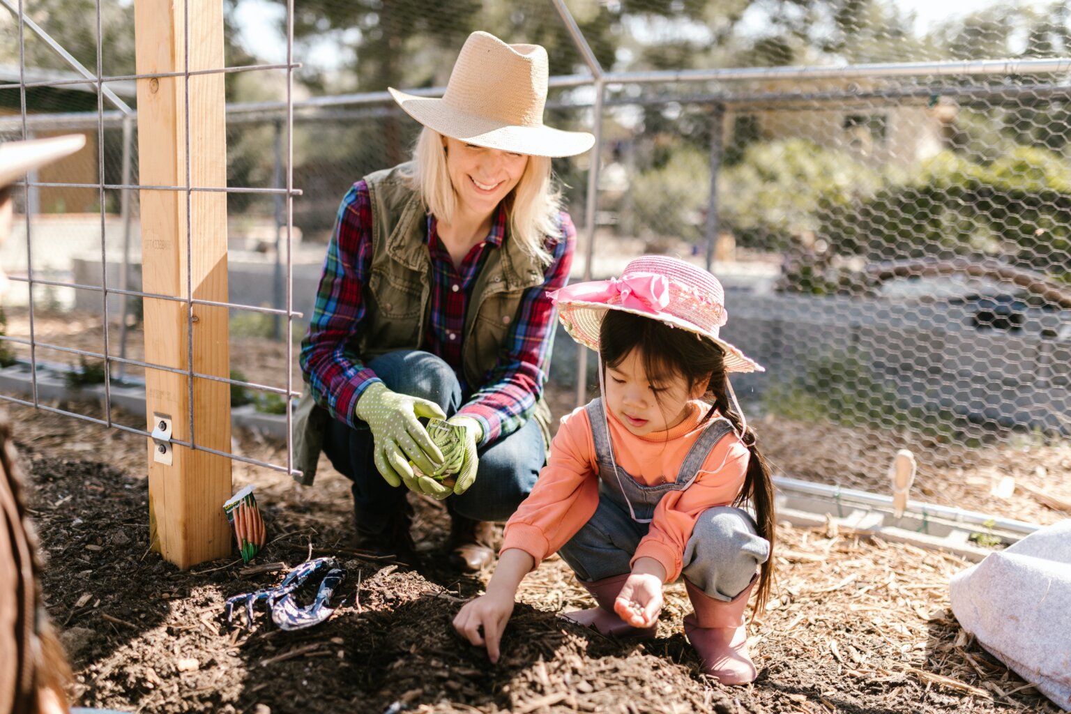 A woman and a child planting seeds.