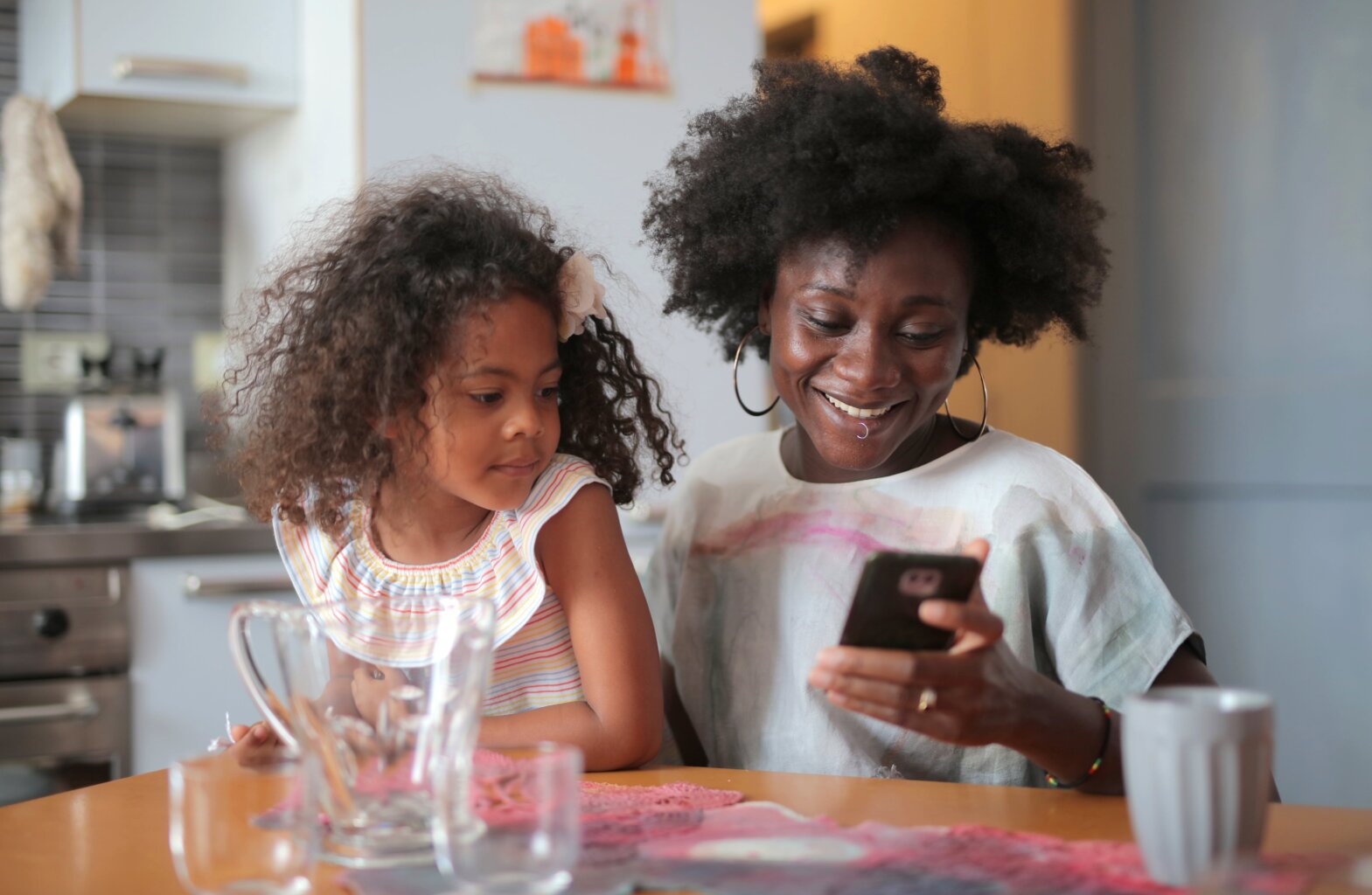 A mom and daughter scrolling through social media on a smart phone.