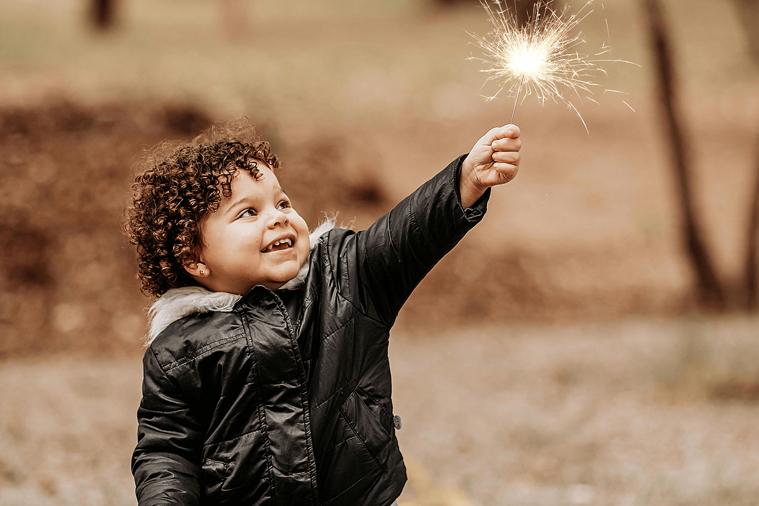 A child holding a sparkler to participate in new year superstitions.