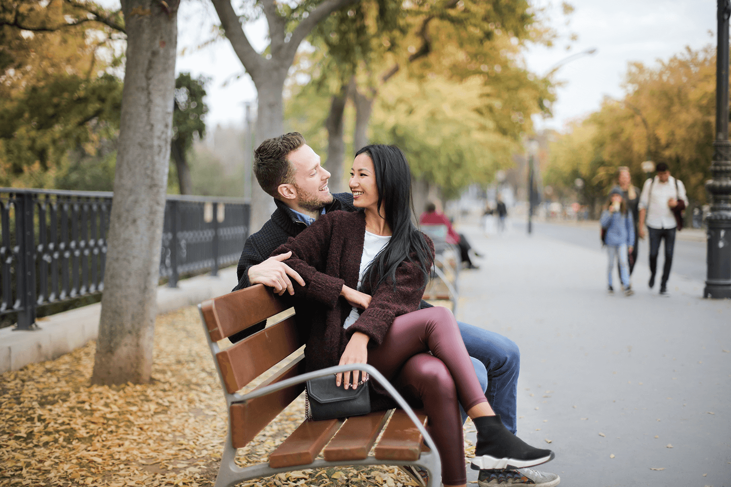 A couple talking to each other while sitting on a park bench so that they avoid miscommunication.