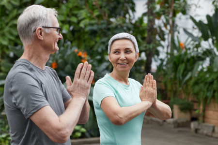 A couple practicing yoga together to take care of their aging bodies.