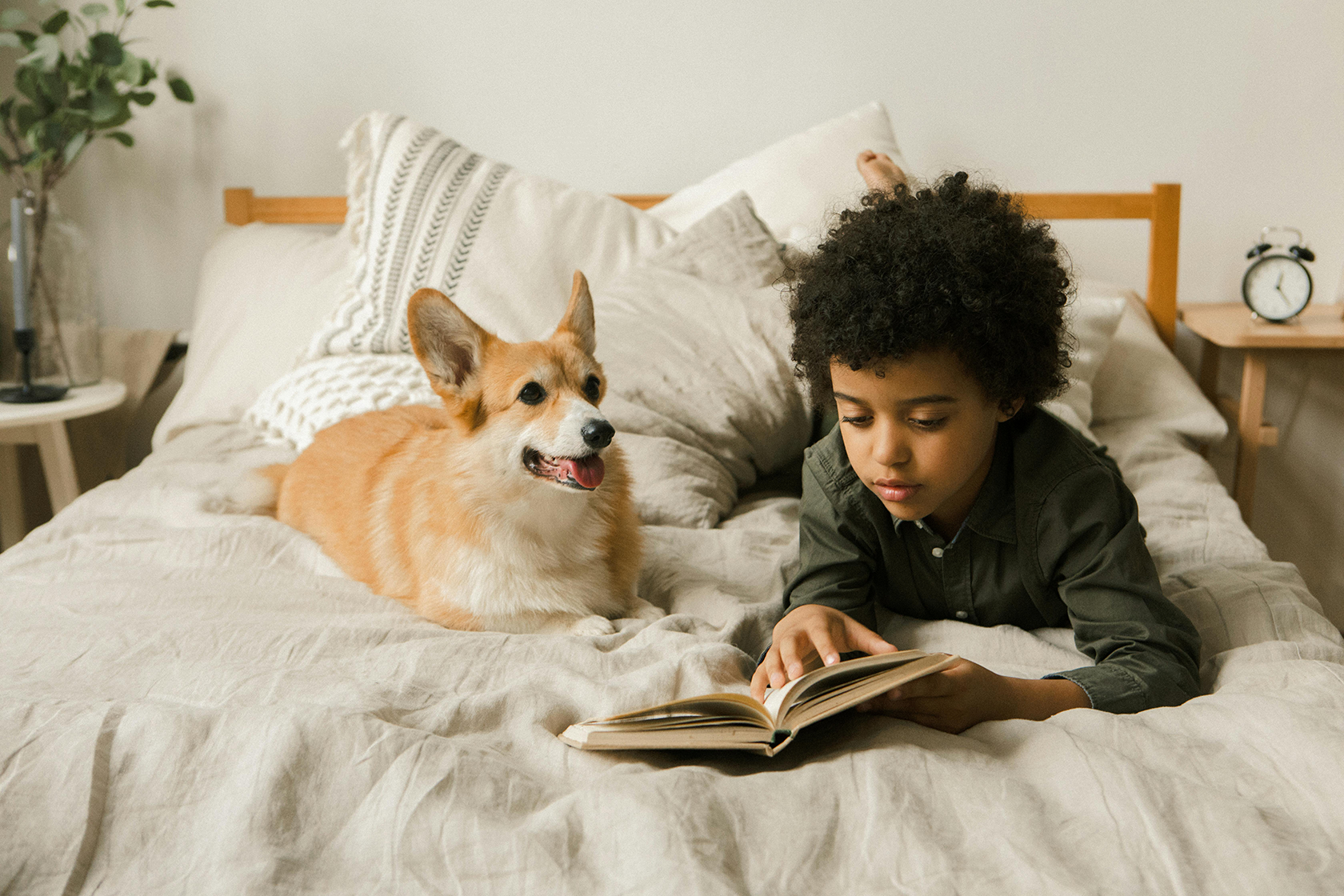 A kid reading with his dog.