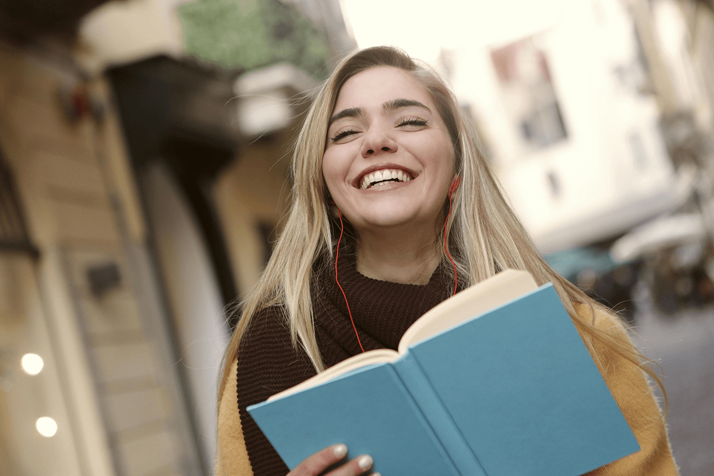 A woman smiling and holding a book.